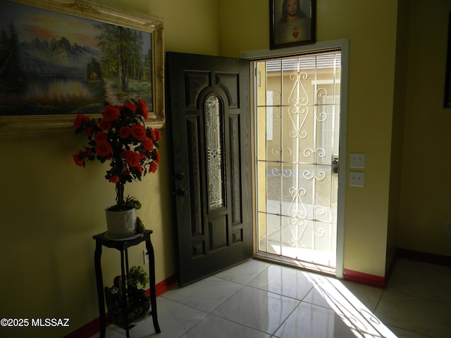 entryway featuring baseboards, plenty of natural light, and marble finish floor