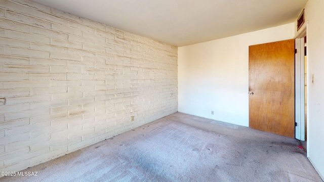 8133 E 6th St, Tucson, AZ 85710 - carpeted empty room featuring brick wall