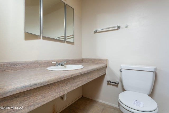 8133 E 6th St, Tucson, AZ 85710 - bathroom with a sink, toilet, baseboards, and tile patterned floors