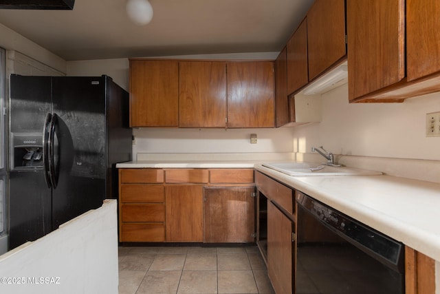 8133 E 6th St, Tucson, AZ 85710 - kitchen with black appliances, a sink, light countertops, and brown cabinetry