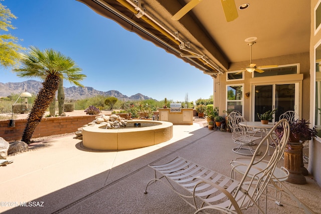 view of patio featuring ceiling fan, a mountain view, and area for grilling