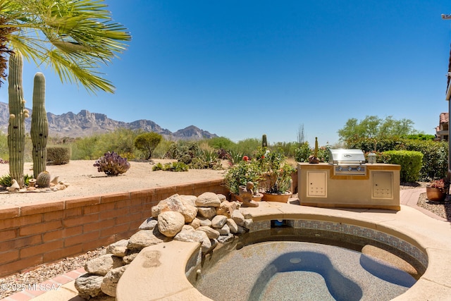 view of patio / terrace with a mountain view, area for grilling, and an outdoor kitchen