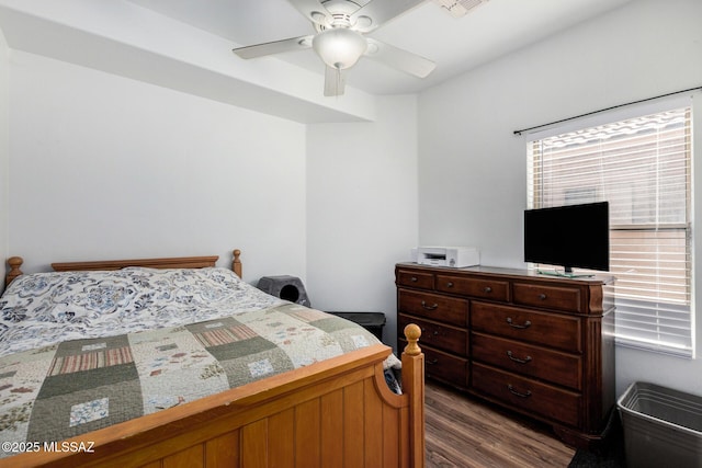 bedroom with a ceiling fan, visible vents, and dark wood-type flooring