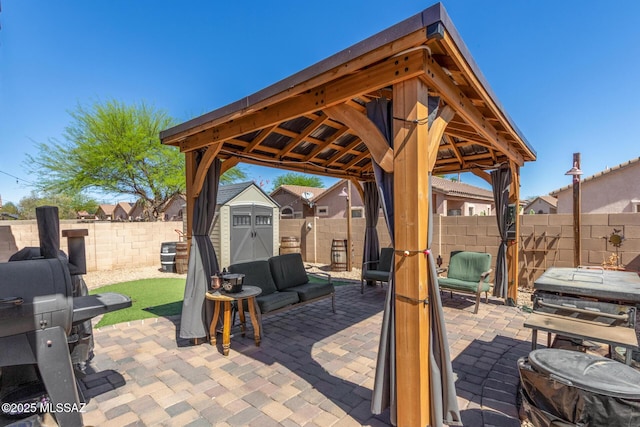 view of patio with a gazebo, outdoor lounge area, a shed, a fenced backyard, and an outdoor structure
