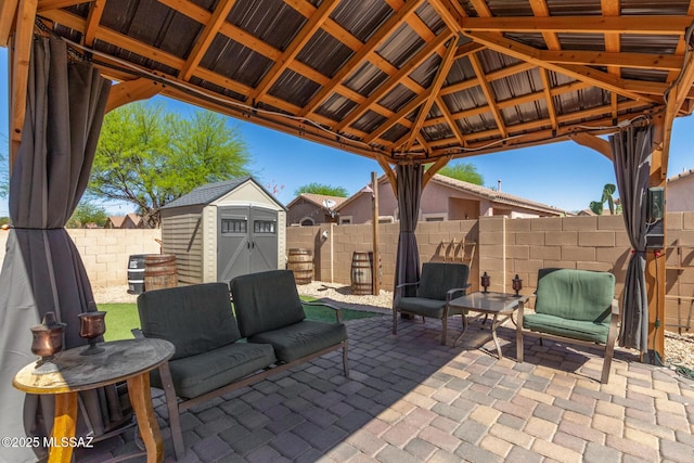view of patio / terrace with an outbuilding, a gazebo, a fenced backyard, a storage unit, and outdoor lounge area