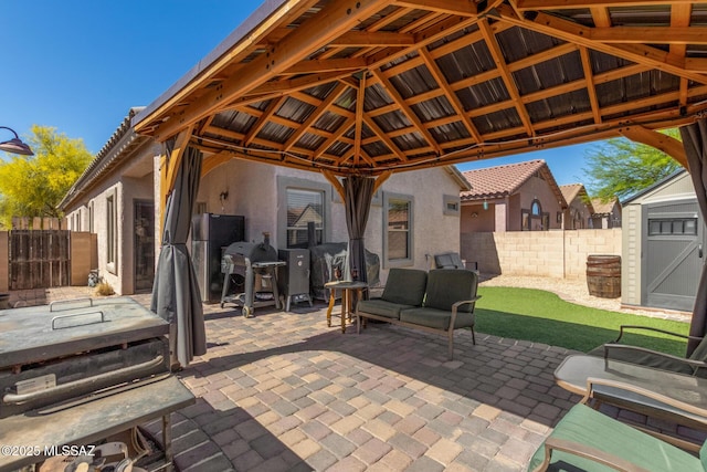 view of patio with a gazebo, an outbuilding, fence, and a storage shed