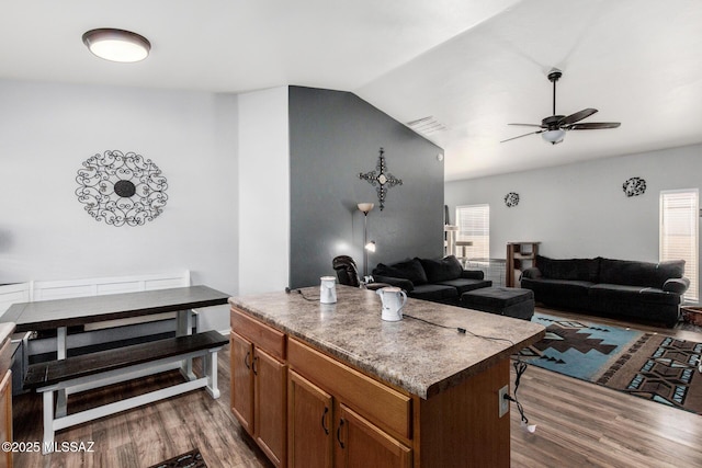 living room with ceiling fan, visible vents, wood finished floors, and lofted ceiling