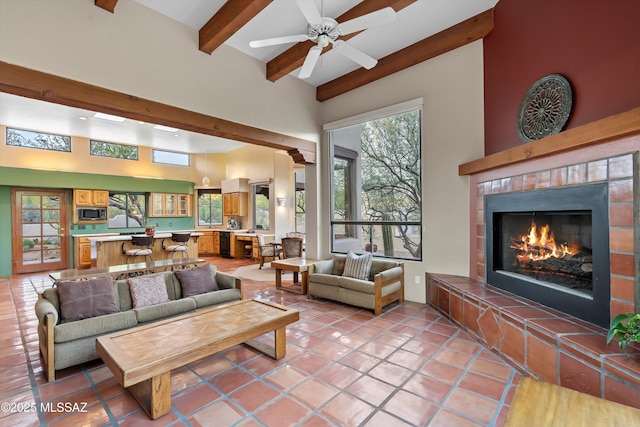 12431 E Cape Horn Dr, Tucson, AZ 85749 - living room with beamed ceiling, a lit fireplace, ceiling fan, a high ceiling, and light tile patterned floors