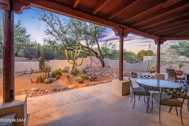 12431 E Cape Horn Dr, Tucson, AZ 85749 - patio terrace at dusk featuring outdoor dining area, a patio, and a fenced backyard