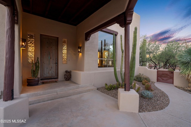 12431 E Cape Horn Dr, Tucson, AZ 85749 - exterior entry at dusk with stucco siding and covered porch