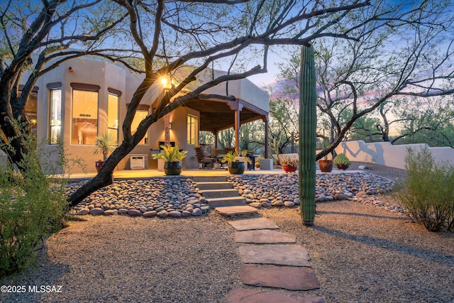 12431 E Cape Horn Dr, Tucson, AZ 85749 - back of house at dusk with stucco siding
