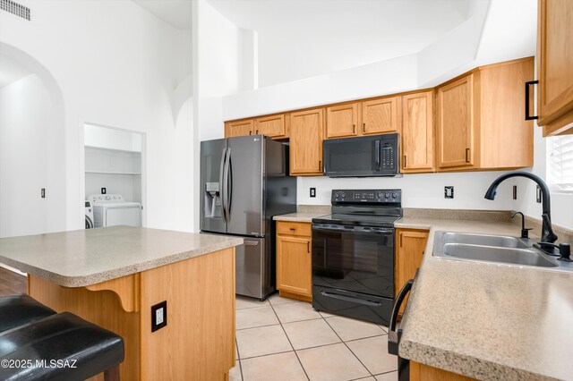 114 W Freddie Canyon Way, Oro Valley, AZ 85755 - kitchen featuring visible vents, separate washer and dryer, a sink, light tile patterned floors, and black appliances