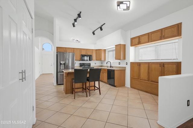 114 W Freddie Canyon Way, Oro Valley, AZ 85755 - kitchen with light tile patterned flooring, a breakfast bar, light countertops, a sink, and black appliances