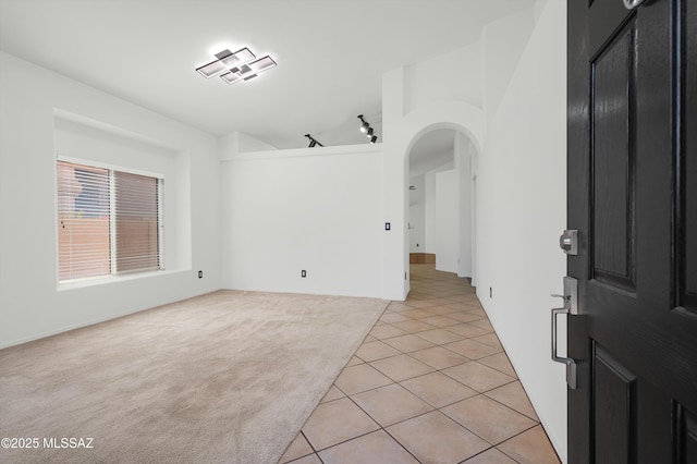 114 W Freddie Canyon Way, Oro Valley, AZ 85755 - spare room featuring arched walkways, light colored carpet, track lighting, and light tile patterned flooring
