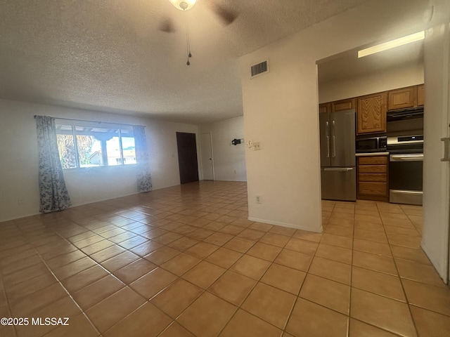 334 S Las Hamacas, Green Valley, AZ 85614 - unfurnished living room featuring light tile patterned flooring and a textured ceiling