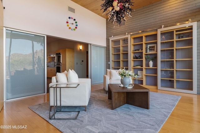 living room featuring visible vents, wood ceiling, wood finished floors, and high vaulted ceiling