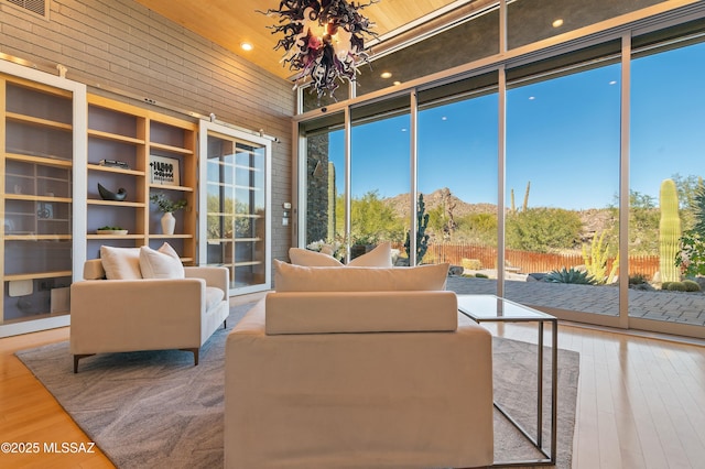 sunroom / solarium featuring plenty of natural light and an inviting chandelier