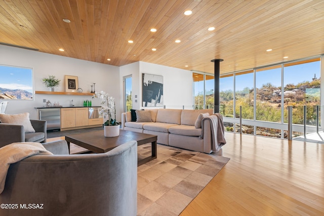 living room featuring indoor wet bar, recessed lighting, a wall of windows, and wooden ceiling