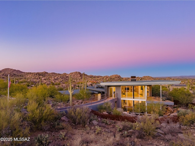 rear view of property with a chimney and a mountain view