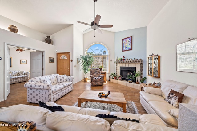 living room featuring high vaulted ceiling, ceiling fan, and a fireplace