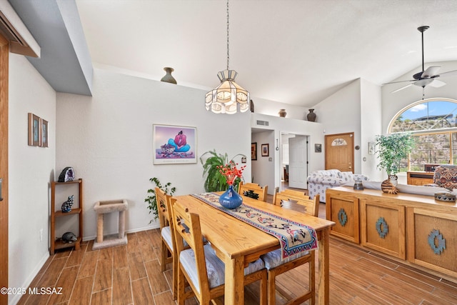 dining area featuring ceiling fan, light wood finished floors, baseboards, lofted ceiling, and visible vents