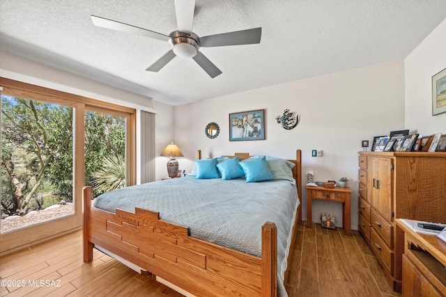 bedroom with a textured ceiling, access to outside, a ceiling fan, and light wood-style flooring