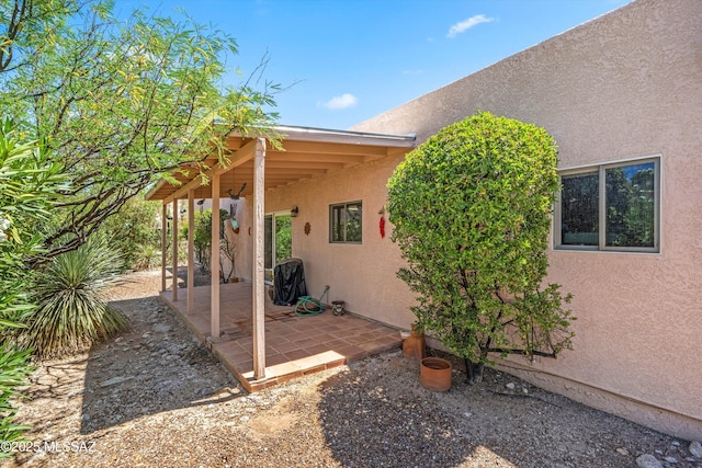 exterior space with stucco siding and a patio area