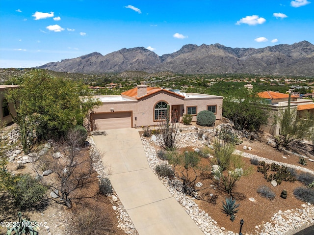mediterranean / spanish home featuring a garage, a mountain view, stucco siding, and driveway