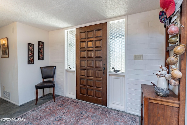 entryway featuring a textured ceiling, visible vents, and baseboards