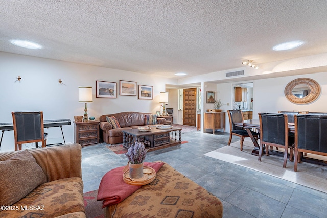 tiled living room with a textured ceiling and visible vents