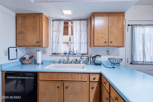 kitchen with light countertops, brown cabinets, a sink, and dishwasher