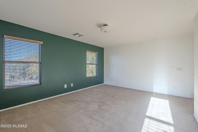 carpeted empty room with baseboards and visible vents