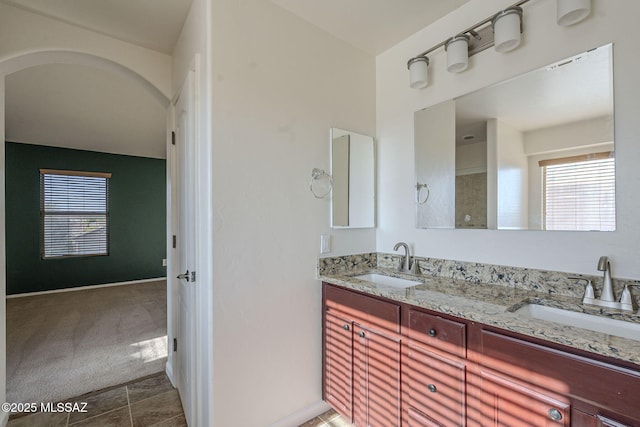 full bathroom with double vanity and a sink