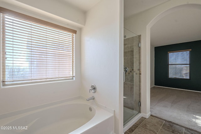 bathroom featuring tile patterned floors, a shower stall, and a bath