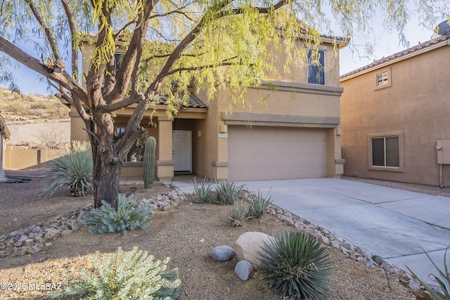 view of front facade with a tiled roof, a garage, stucco siding, and driveway