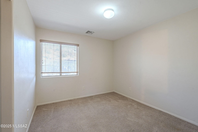 carpeted empty room featuring baseboards and visible vents