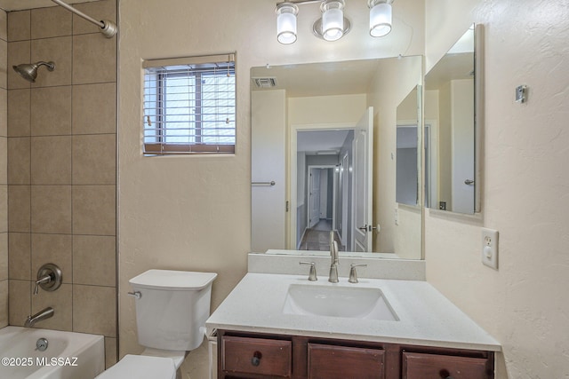 bathroom with toilet, visible vents, washtub / shower combination, and vanity
