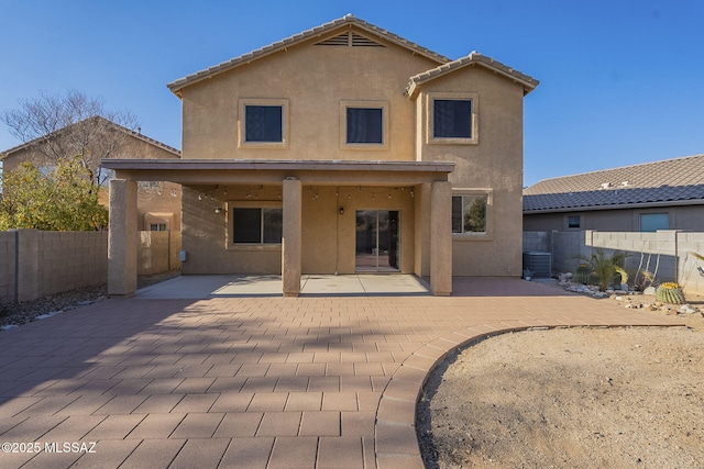 back of property featuring a fenced backyard, a patio area, and stucco siding