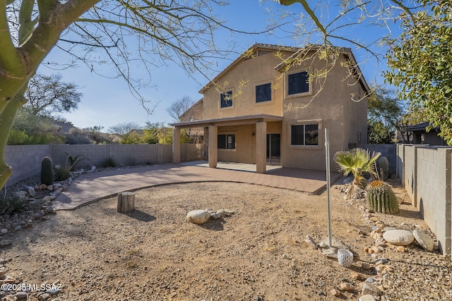 back of property featuring a fenced backyard, stucco siding, and a patio area