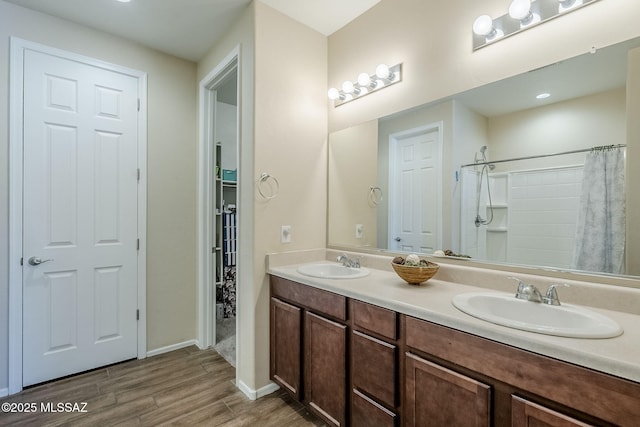 15726 S Camino Oculi, Sahuarita, AZ 85629 - bathroom with double vanity, a shower with curtain, a sink, and wood finished floors