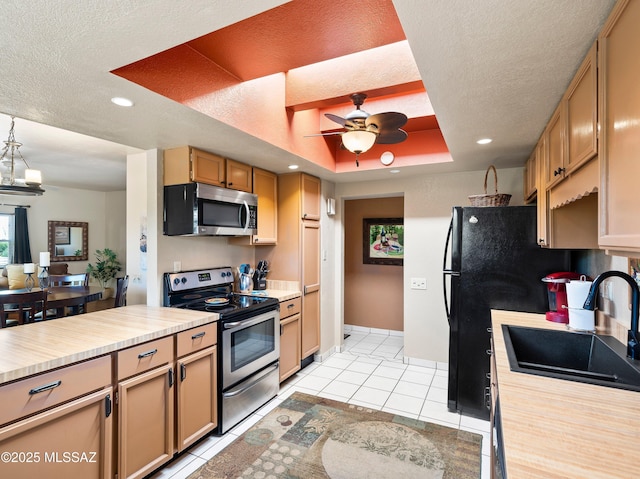 kitchen with light countertops, ceiling fan, appliances with stainless steel finishes, and a sink