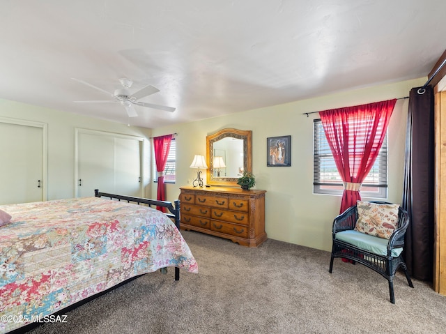 bedroom with carpet, ceiling fan, and multiple closets