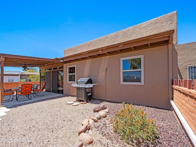 rear view of property with fence, a patio area, and stucco siding