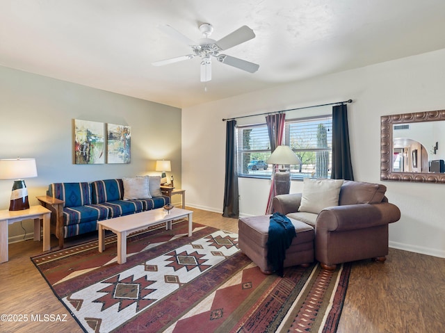 living room featuring a ceiling fan, baseboards, and wood finished floors