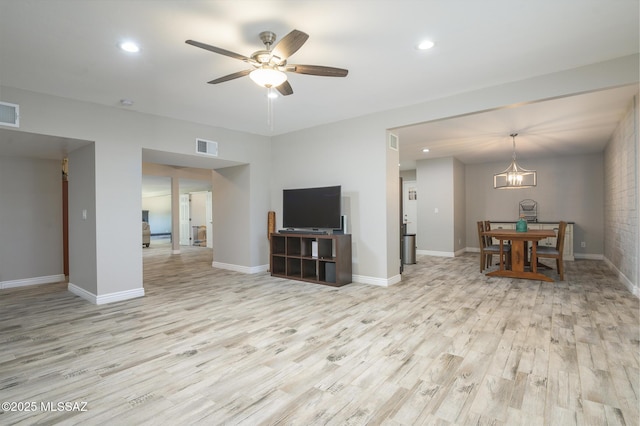 living area featuring light wood-style flooring, ceiling fan with notable chandelier, recessed lighting, baseboards, and visible vents