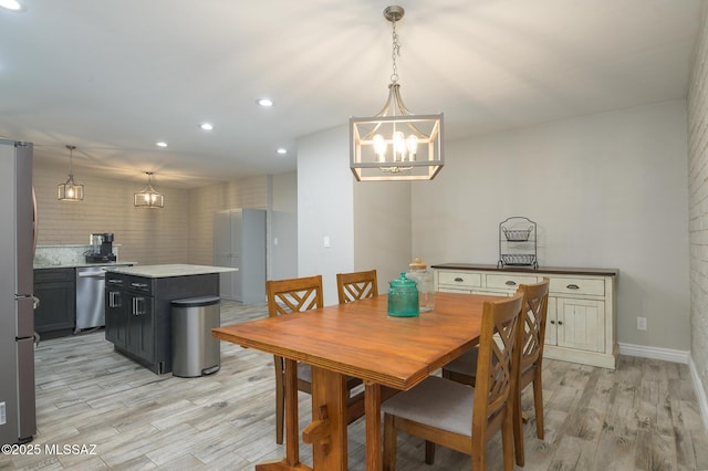 dining space with recessed lighting, baseboards, a notable chandelier, and light wood finished floors
