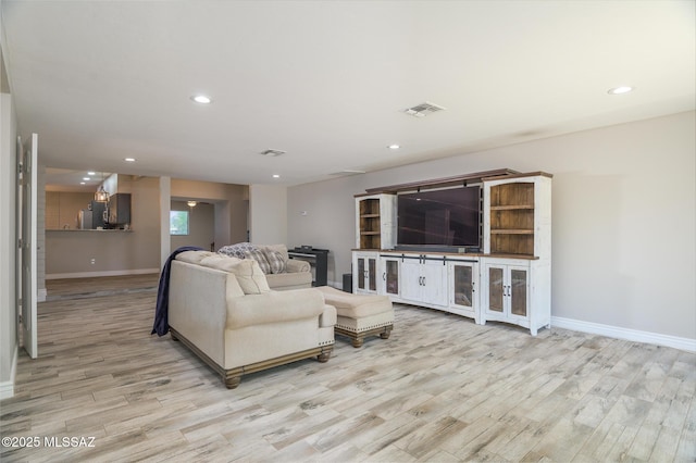 living room with recessed lighting, baseboards, visible vents, and light wood-type flooring