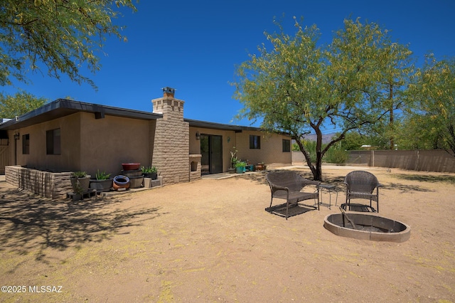 rear view of house featuring a fenced backyard, a chimney, a patio area, and stucco siding