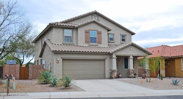 view of front of home with driveway, a tile roof, fence, an attached garage, and stucco siding