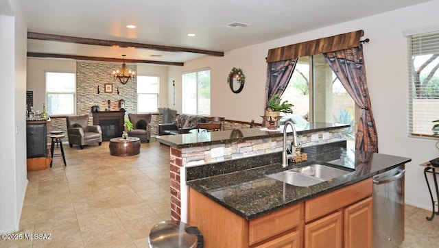 kitchen with a sink, an island with sink, open floor plan, stainless steel dishwasher, and visible vents